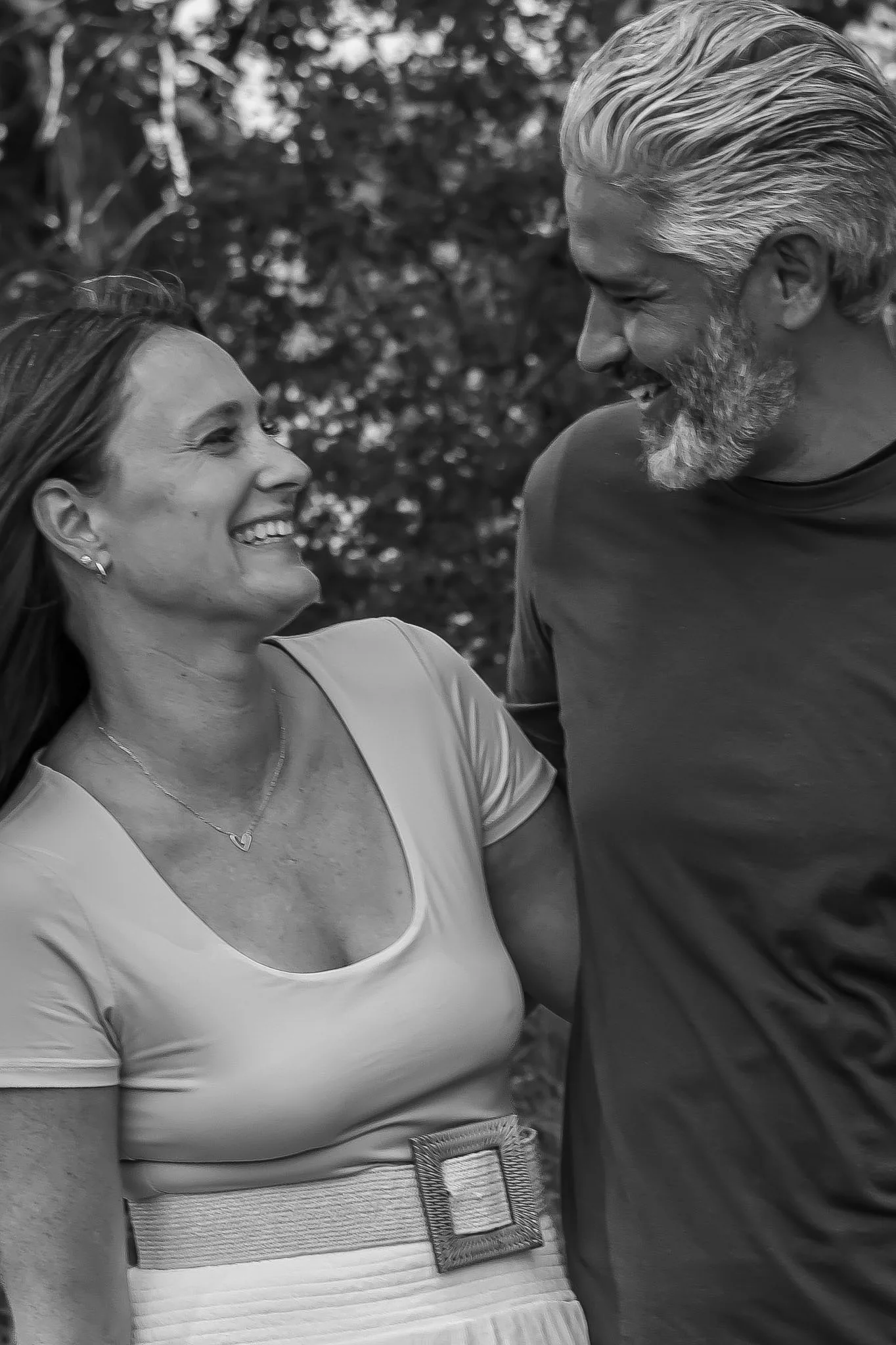 Couple smiling together in a black-and-white portrait.