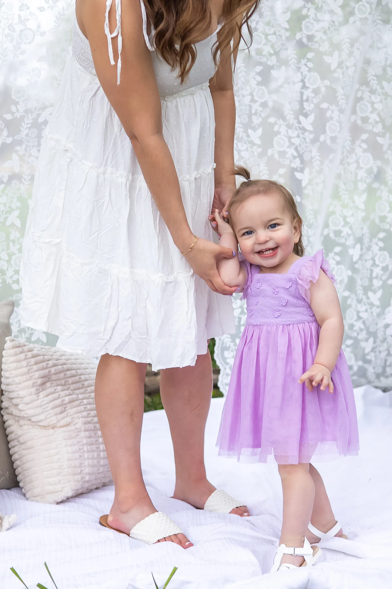 Mother and young daughter holding hands for a portrait.