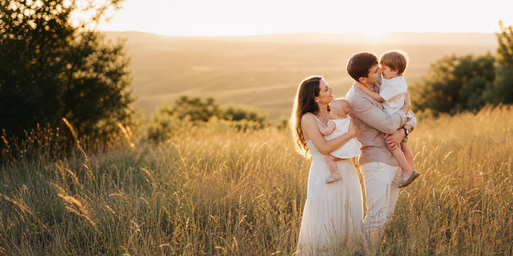 Family sharing a candid moment in a golden meadow.